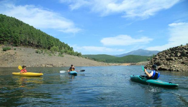 Tres piragüistas en el pantano de El Vado con el pico Ocejón de fondo